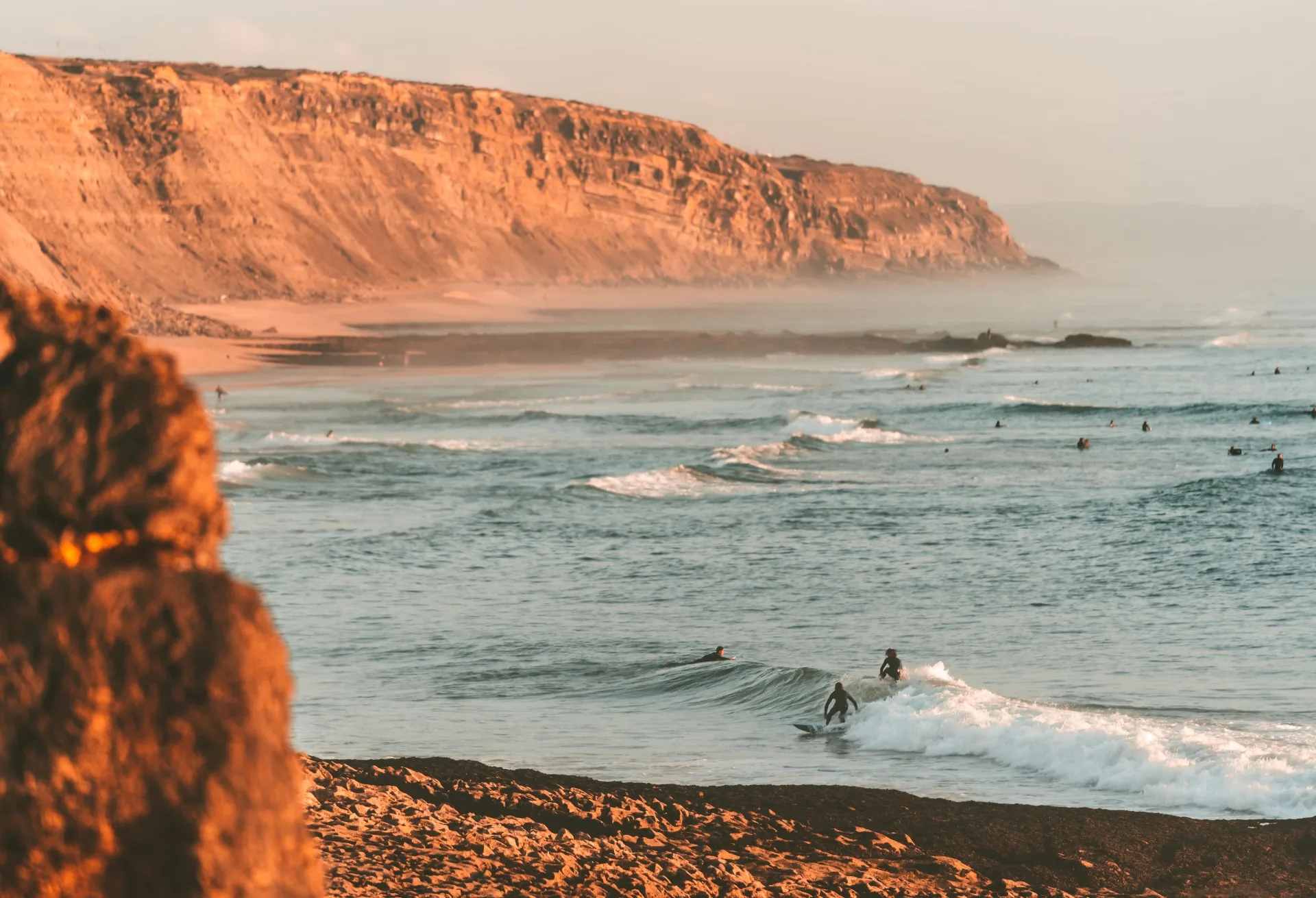 Surfers at golden hour in Ericeira